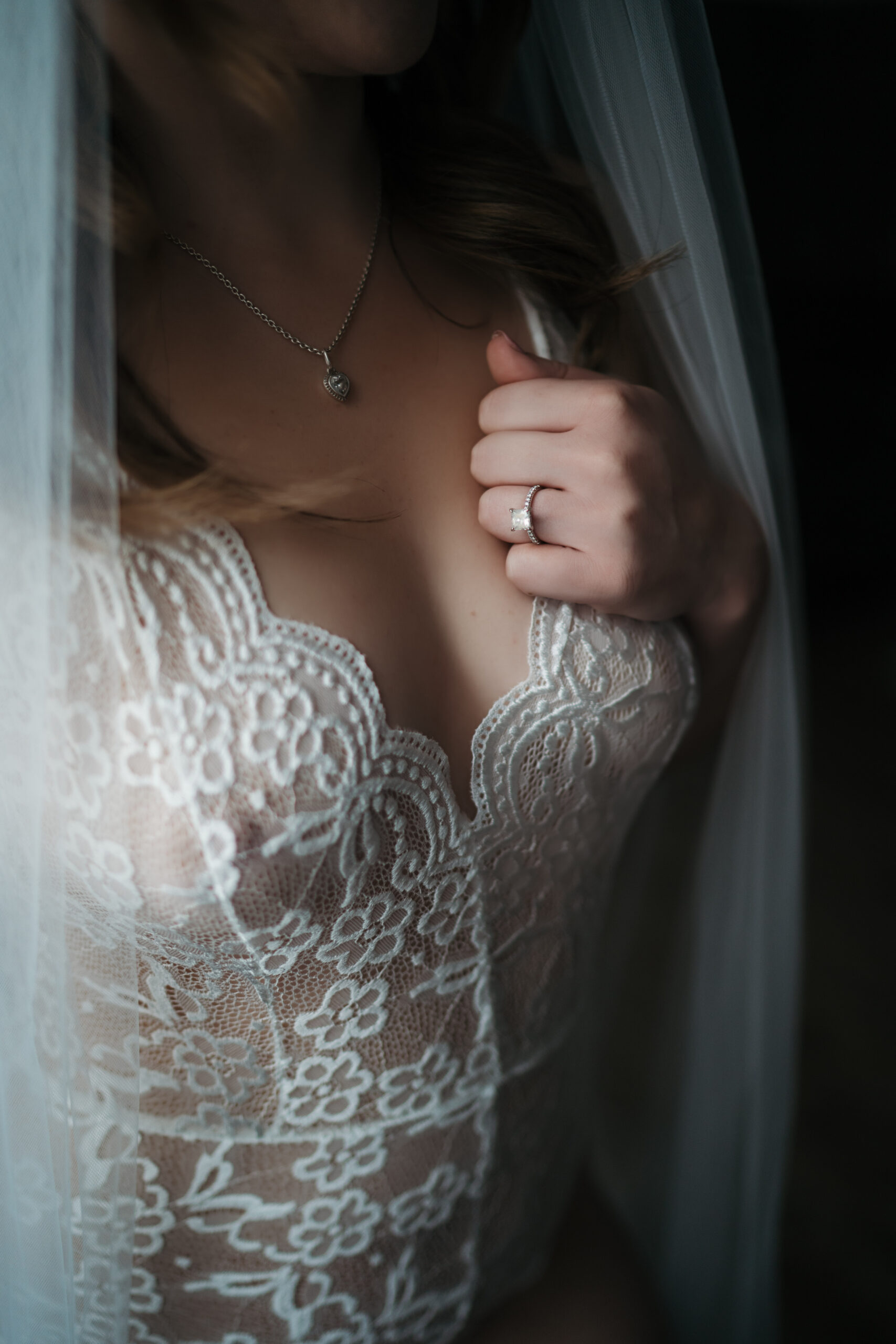 woman in white lingerie showing off her engagement ring